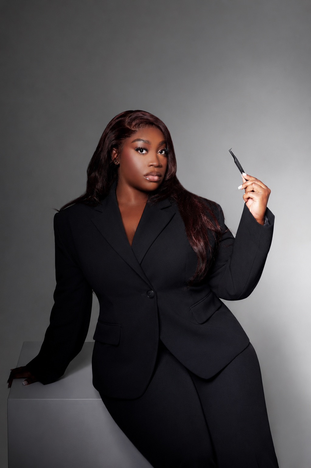 Decardi Beauty founder holding lash tweezers